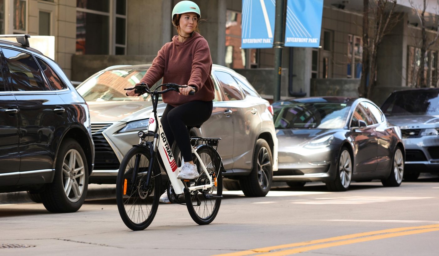 Adult rider on a step-through commuter e-bike in a city setting