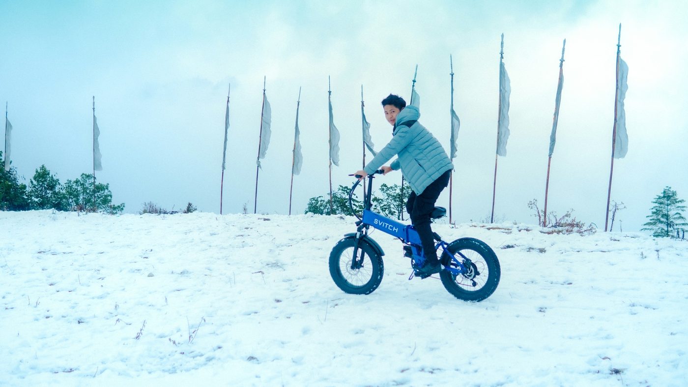 Compact folding-style e-bike being ridden in snowy conditions